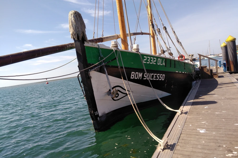 Close-up of the bow of the traditional wooden Caique sailing ship "BOM SUCESSO" docked in the marina in Olhao, Portugal.
