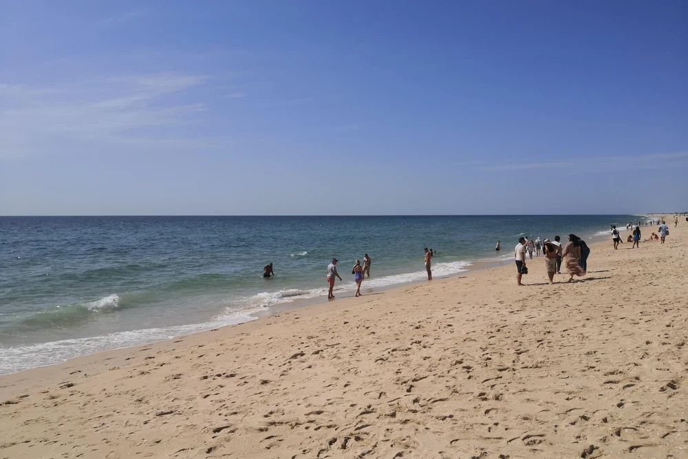 Wide, sandy beach and blue Atlantic Ocean on Ilha de Tavira, a popular island beach destination near Tavira, Portugal.