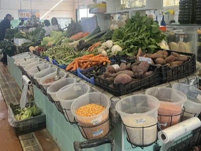 A vibrant market stall at the Sagres municipal market, overflowing with fresh, colourful local vegetables, grains, and legumes.
