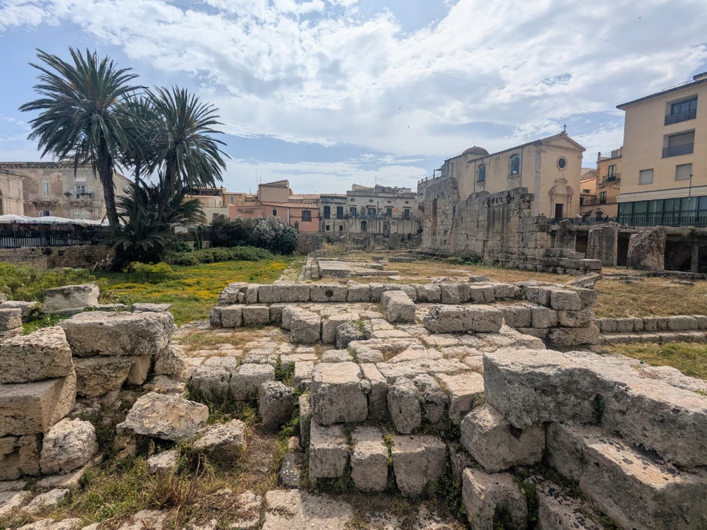 Ancient stone ruins of the Temple of Apollo at the entrance to Ortigia