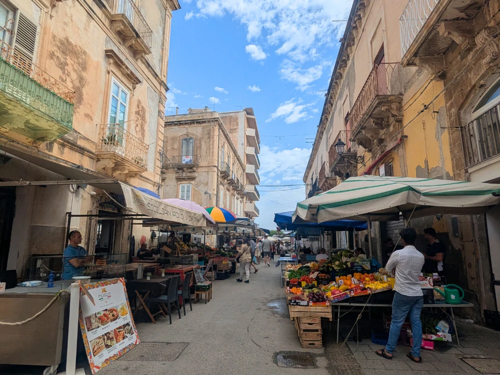 Local vendors and fresh produce at the Ortigia morning market near the Temple of Apollo