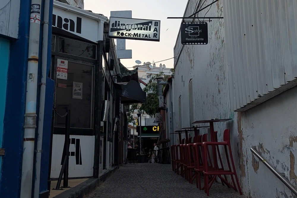 Narrow alley in Praia da Rocha, Portimão, featuring Diagonal Rock-Metal Bar and surrounding nightlife venues