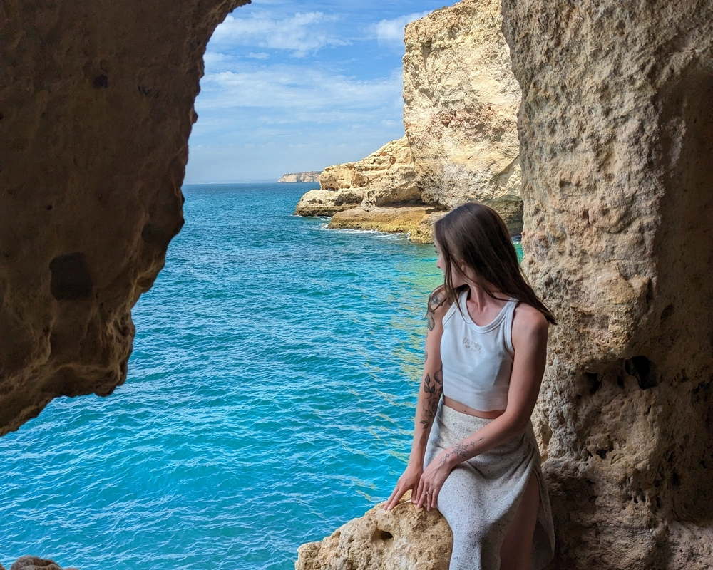 Woman sitting in the Boneca Cave outlook in Carvoeiro
