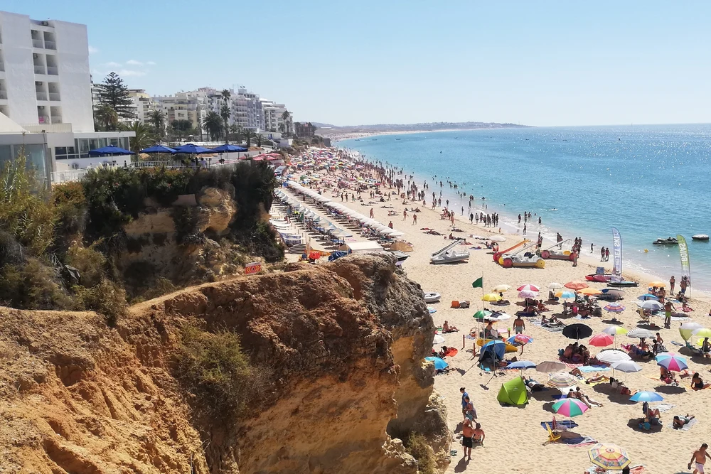 People enjoying the main city beach view from the cliff in Armação de Pêra, Algarve