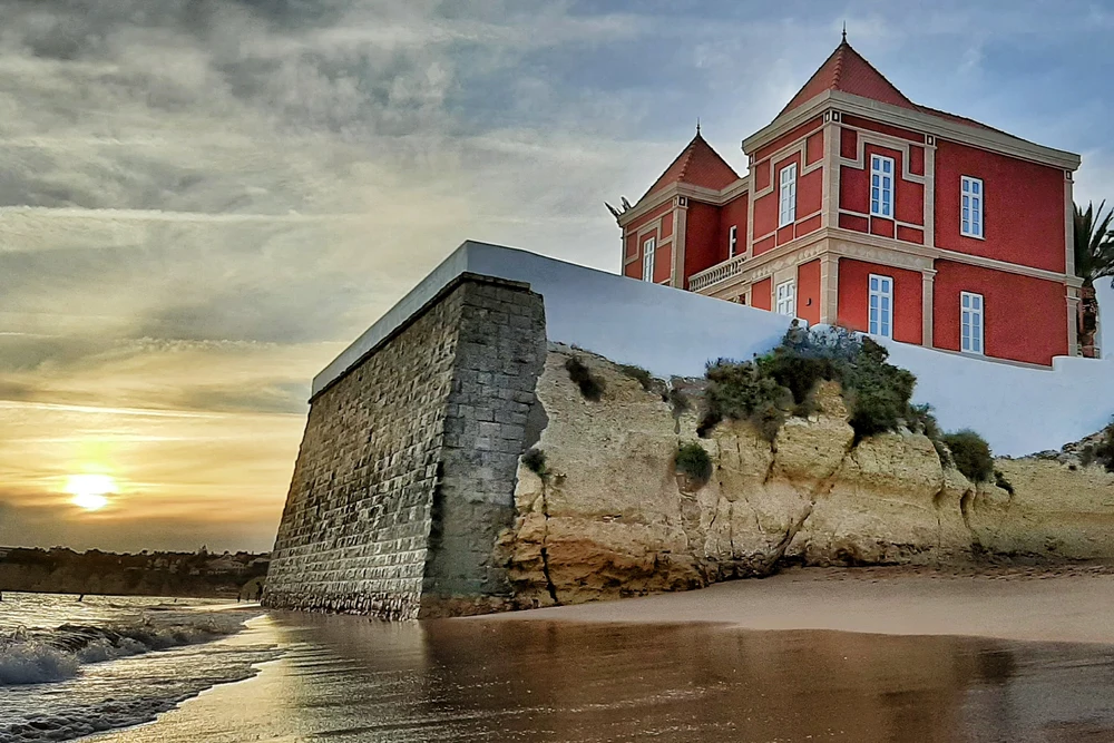 Red Vila Chalet on the beach at sunset in Armação de Pêra, Algarve