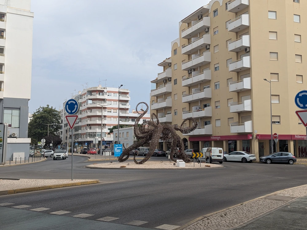 A large metal octopus sculpture in a roundabout on Avenida Francisco Sá Carneiro in Quarteira, Portugal.