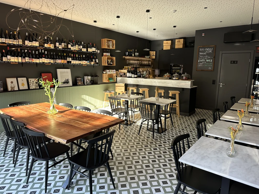 The stylish, modern interior of Bago Wine Bar in Faro, featuring a wall of fine wines and contemporary decor.
