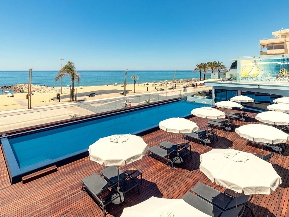 The beautiful swimming pool and sundeck overlooking the sandy beach at Dom Jose Beach Hotel in Quarteira.