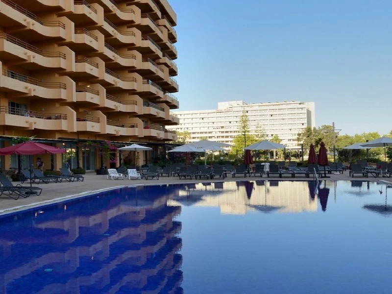The large outdoor swimming pool and sun loungers at the Dom Pedro Portobelo Hotel, a popular accommodation choice in Vilamoura.