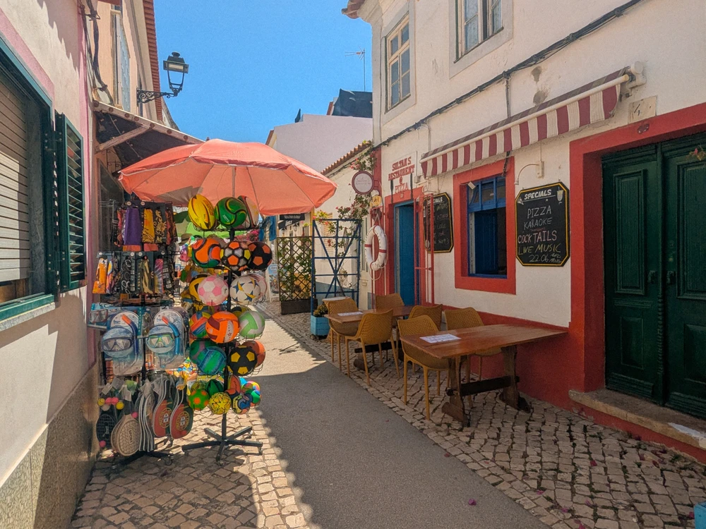 Artisan shops lining small cobblestone streets in Ferragudo