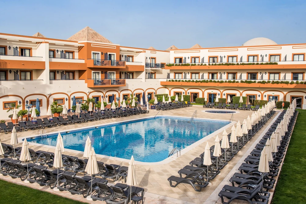 Aerial view of the large outdoor swimming pool and sun loungers at the Vila Galé Tavira Hotel and resort in the Algarve.