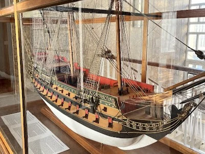 An intricate, detailed model of a historic naval vessel on display at the Faro Maritime Museum (Museu Marítimo).