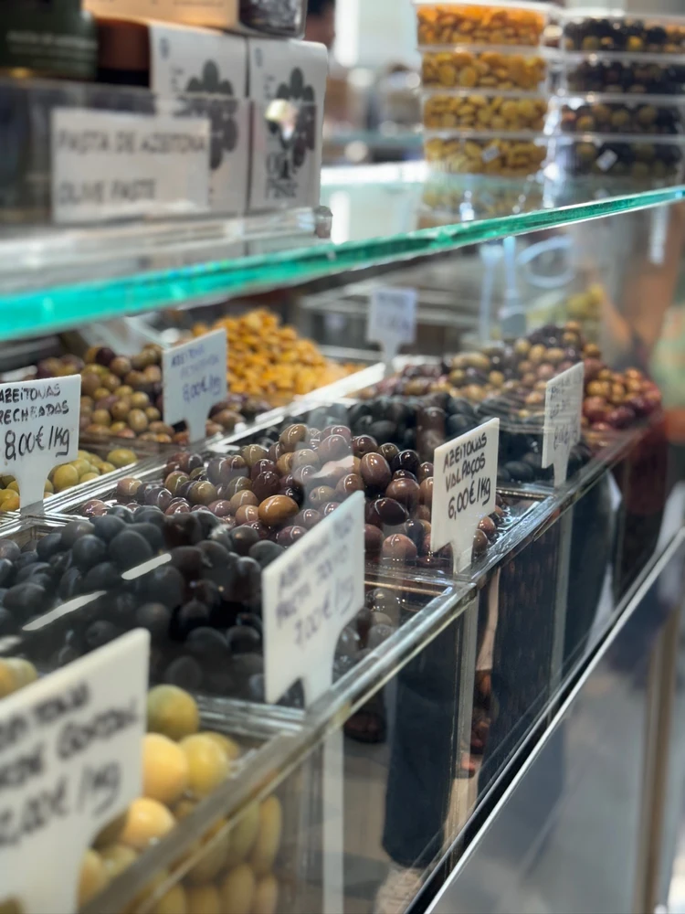 A variety of fresh olives on display at a market stall inside Mercado do Bolhão in Porto.