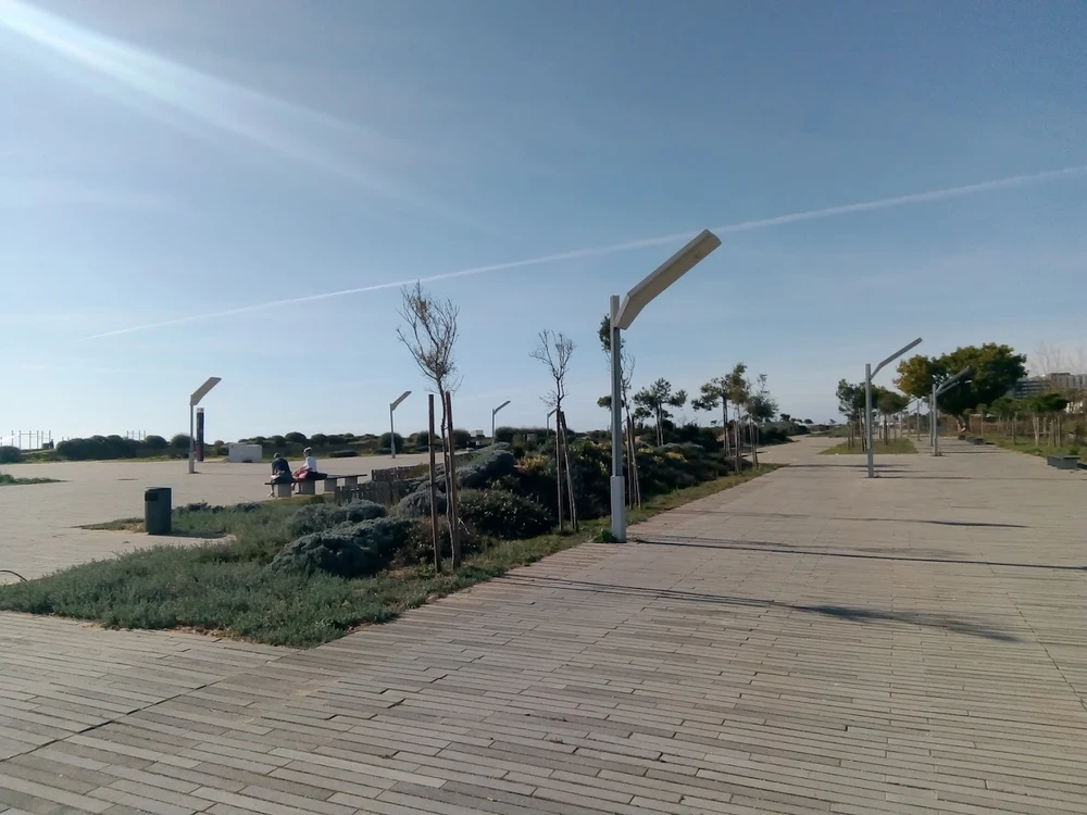 A view along the wide, paved Passeio das Dunas boardwalk, a scenic walking path in Quarteira.