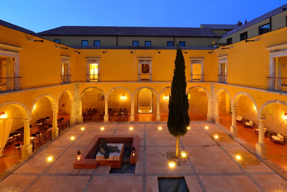 The illuminated inner courtyard and arcades of the luxurious Pousada Convento de Tavira hotel, converted from a historic convent.
