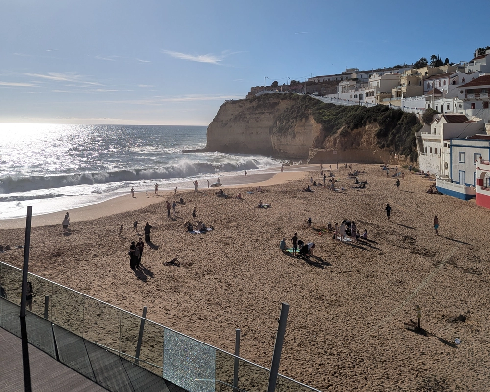 Praia de Carvoeiro beach front with waves rolling onto the shore and cliffs surrounding the beach