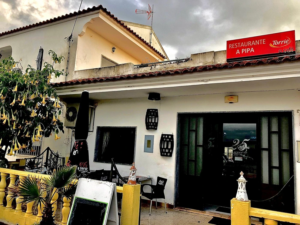 The exterior of the traditional A Pipa Restaurant on a cloudy day in Quarteira.