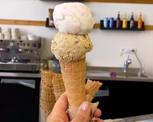 A two-scoop ice cream cone with pistachio and vanilla gelato from the artisanal shop REŸS - Glaces Éternelles in Príncipe Real.