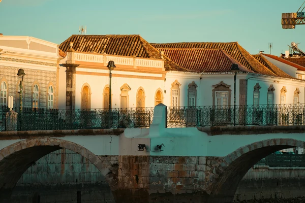 Beautiful sunset light on the traditional historic architecture next to the Gilão River bridge in the center of Tavira, Portugal.