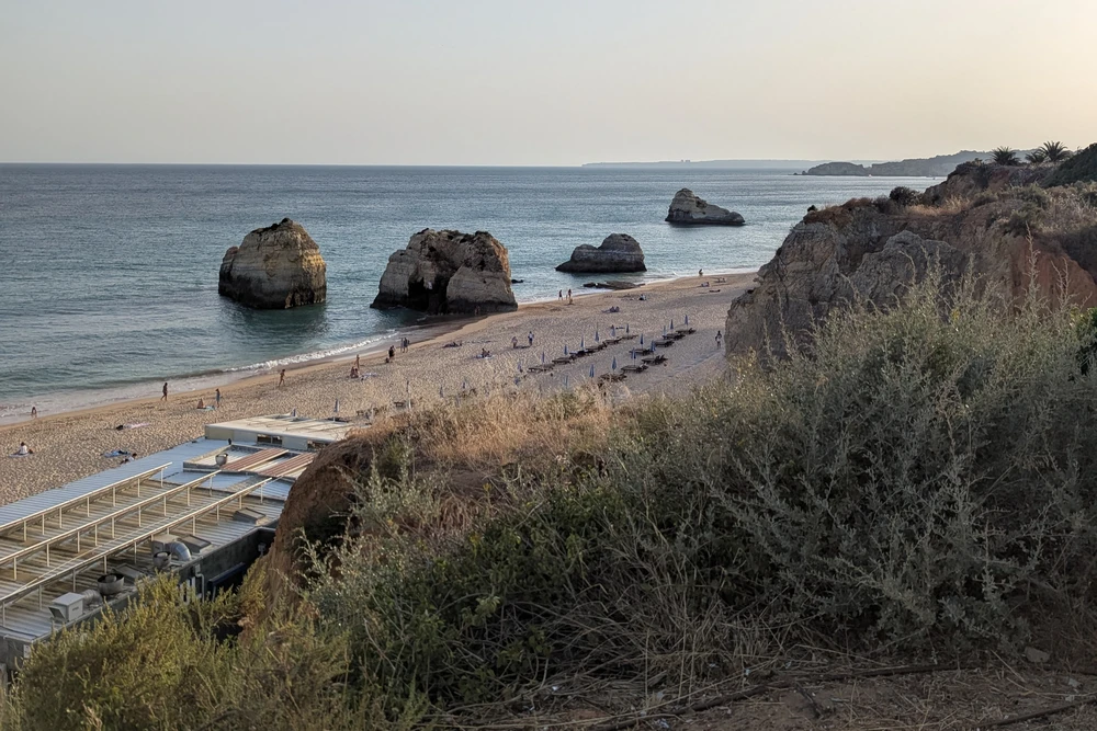 Scenic view of Três Castelos Beach in Portimão with iconic sea stacks, golden sand, and calm Atlantic waters