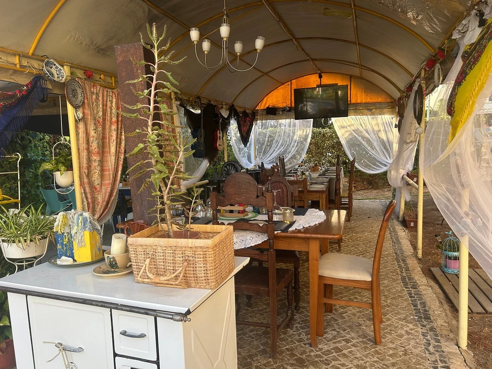 The charming and rustic covered terrace of Vila Com Tradicao Restaurant, a traditional Portuguese dining spot for visitors in Vilamoura.